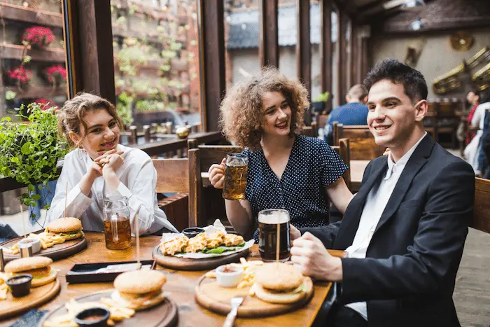 3 personas comiendo en un restaurante lindo con buena iluminación